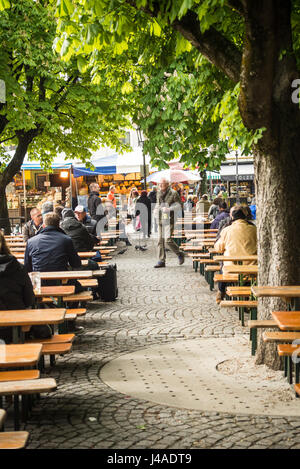 München, Deutschland-Mai 9, 2017:People sitzen in einem Biergarten in der Viktualienmarkt, die späten Nachmittag Sonne genießen Stockfoto