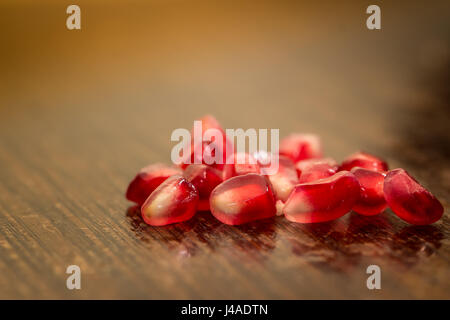 Closeup Granatapfelkernen auf Holztisch mit Textfreiraum Stockfoto
