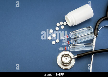 Stethoskop, Tabletten, Ampullen im Arztzimmer auf blauem Hintergrund Draufsicht mockup Stockfoto