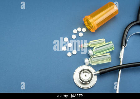 Stethoskop, Tabletten, Ampullen im Arztzimmer auf blauem Hintergrund Draufsicht mockup Stockfoto