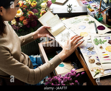 Hände halten trockene Blumen Pflanzen Sammlung Notebook Stockfoto