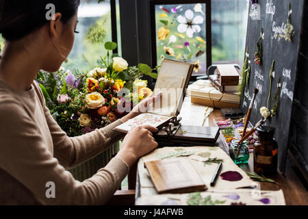 Hände halten trockene Blumen Pflanzen Sammlung Notebook Stockfoto
