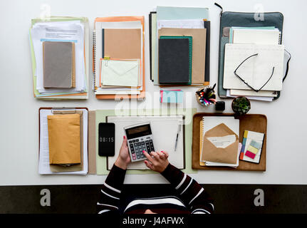 Hände arbeiten am Schreibtisch mit Notebooks und Briefpapier auf weißen Tisch Stockfoto