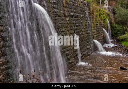 Quadratische Betonsteine Verdammung auf dem Fluß mit Löchern für Abwasser Stockfoto