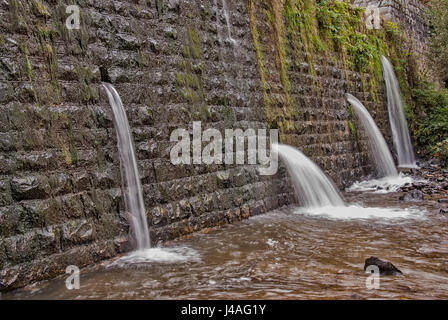 Quadratische Betonsteine Verdammung auf dem Fluß mit Löchern für Abwasser Stockfoto