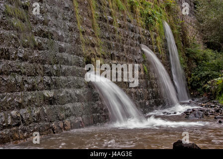 Quadratische Betonsteine Verdammung auf dem Fluß mit Löchern für Abwasser Stockfoto