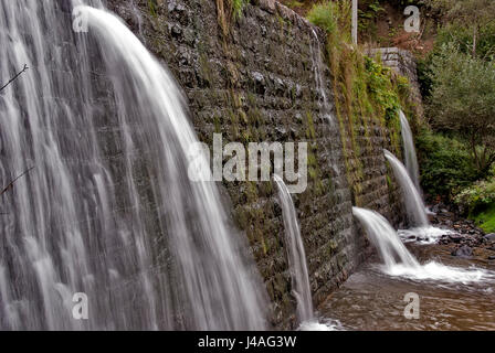 Quadratische Betonsteine Verdammung auf dem Fluß mit Löchern für Abwasser Stockfoto