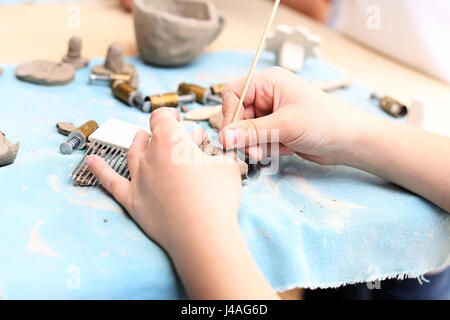 Keramik-Kurs für Kinder. Der junge ist aus Ton bei einem Kunststoff Workshop krallt. Außerschulische Aktivitäten, Keramik. Stockfoto