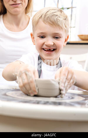 Keramik-Kurs für Kinder. Der junge ist aus Ton bei einem Kunststoff Workshop krallt. Stockfoto