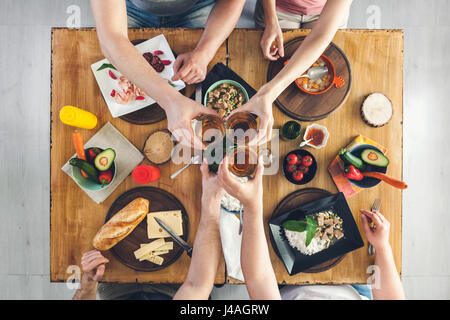 Ansicht von oben, Gruppe von Menschen sitzen am Holztisch mit Essen, ein Getränk Stockfoto