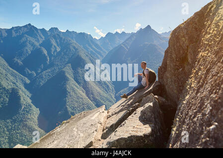 Menschen sitzen auf Berggipfel im sonnigen Sommertag, lächelnd Mann mit Rucksack auf Wandern Stockfoto