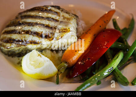 Kanadischer Lachs serviert auf einem Bett aus Reis mit frischem Gemüse in Vancouver, Kanada. Der Lachs hat gegrillt. Stockfoto