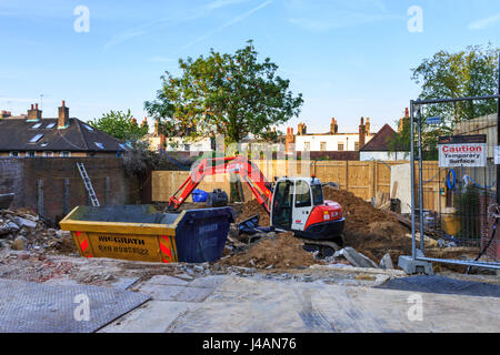 Eine mechanische Digger und ein Überspringen auf einer Baustelle in, London, UK Stockfoto