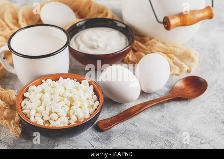 Granulierter Cottage Quark, Sauerrahm und Tasse Milch auf hellem Hintergrund Stockfoto