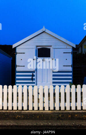 Blau und weiß buche Hütte bei Nacht, durch die straßenlaterne beleuchtet, an der Promenade von Westward Ho!, Devon, Großbritannien Stockfoto