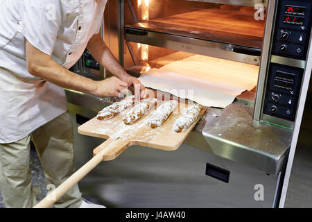 Baker bereitet Brot backen im Ofen Stockfoto