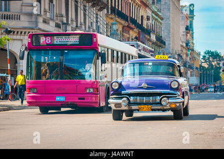 Havanna - Juni 2011: Ein amerikanische Oldtimer aus den 1950er Jahren fährt neben einer modernen europäischen Bus, ein Zeichen der Modernisierung der Stadt, Stockfoto