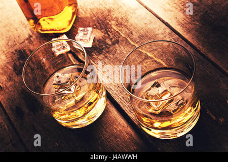 Whisky mit Eis auf alten dunklen Holztisch Stockfoto