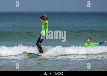 Ein Surf-Schule-Neuling surft zum ersten Mal Fistral Strand Newquay Cornwall Surfen Surfer Lerner lernen am Meer Meer Tourismus Stockfoto