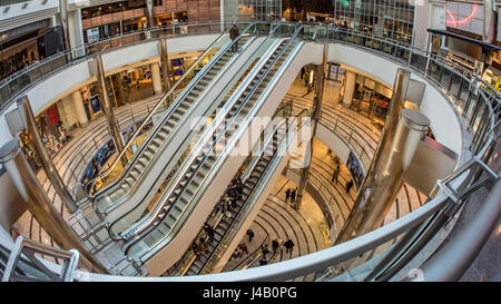 Fisch Auge Aussicht auf Rolltreppen mit Menschen eilen durch in einem Einkaufszentrum in Canary Wharf, London Stockfoto