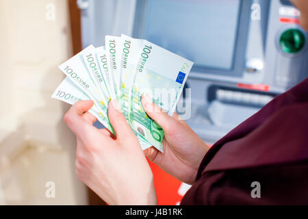 Rückzahlung auf Kredit. Frau Hand Geldabheben von Outdoor-Bank ATM Stockfoto