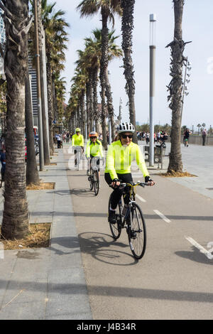 Radfahrer, die ihr Fahrrad auf einer Palme ausgekleidet Fahrradweg an der Strandpromenade von La Barceloneta, Barcelona, Spanien. Stockfoto