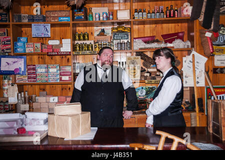 Eine männliche und weibliche Verkäuferinnen im Co-Operative Geschäft bei Beamish Museum, England, UK Stockfoto