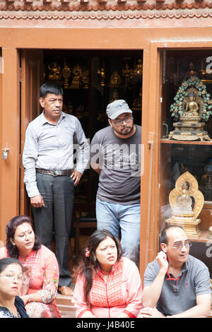 Menschen in einem Shop Eingang auf den Straßen von Patan oder Lalitpur Buddha Tag Prozessionen, Kathmandu Nepal zu sehen Stockfoto