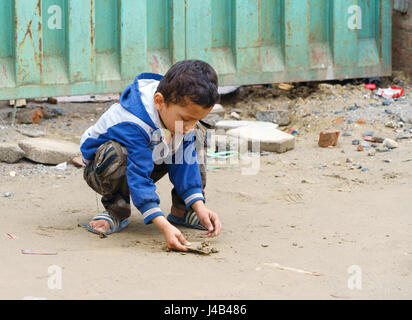 Junge nepalesische Junge spielt mit Sand in khatmandu. Stockfoto