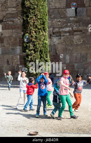 Kinder spielen mit den großen Seifenblasen. Stockfoto