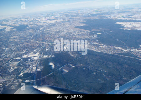 FRANKFURT, Deutschland - 20. Januar 2017: Blick durch Fenster Flugzeug Jet Flügel, Wingview über Schnee bedeckt Stadt Frankfurt Am Main, Flughafen FRAPORT im Hintergrund Stockfoto