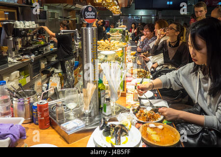 Leute sitzen an der Bar Essen Meeresfrüchte Tapas im Mercat de Sant Josep De La Boqueria, Barcelona Spanien. Stockfoto