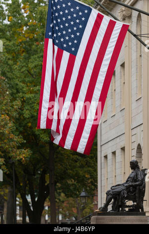 Die Statue von John Harvard unter die Stars And Stripes in Harvard University Stockfoto