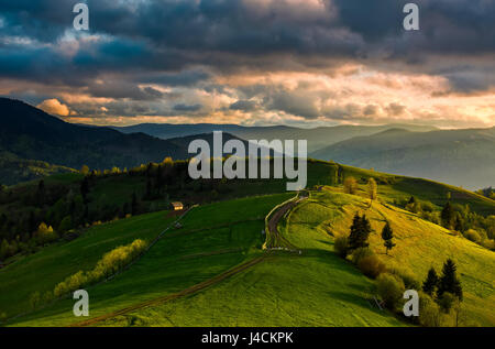 Frühling Zeit ländliche Landschaft. Holzzaun entlang des Pfads durch landwirtschaftliche Felder in Karpaten Stockfoto