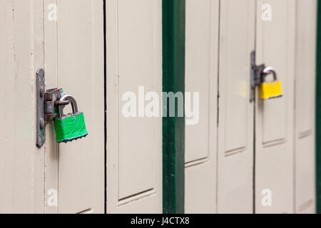 Farbige Vorhängeschlösser auf eine Metallklammer, Holztüren zu sichern. Stockfoto