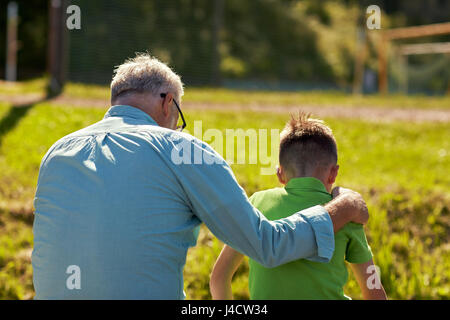 Großvater und Enkel umarmt im freien Stockfoto