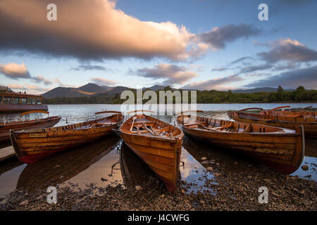 Ruderboote bei Sonnenaufgang am Ufer des Derwentwater im Lake District, Cumbria, England UK Stockfoto