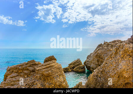 Felsen an der Küste Wellen reflektiert Sonnenstrahlen in klarem Wasser, Mittelmeer an der Costa Del Sol, Andalusien, Spanien Stockfoto