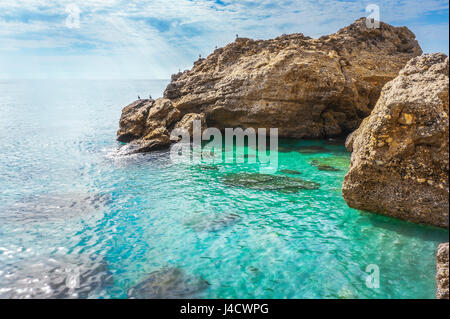 Felsen an der Küste Wellen reflektiert Sonnenstrahlen in klarem Wasser, Mittelmeer an der Costa Del Sol, Andalusien, Spanien Stockfoto