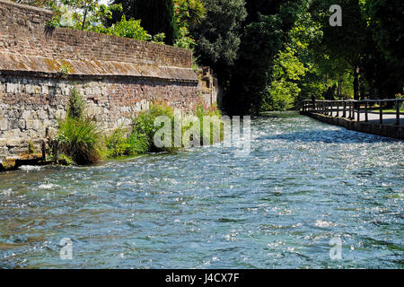 Sonnenschein glitzert aus den turbulenten Gewässern des Flusses Itchen Durchströmen der Wehre öffentlichen Raum in der Mitte des historischen Winchester, UK. Stockfoto