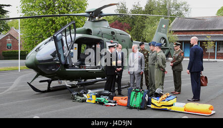 Der Prince Of Wales wird eine EC 135 Rettungshubschrauber von Vizeadmiral Mark Mellett (links) gezeigt, wie er The Irish Defence Forces besucht / UN Training Schule in Curragh, in der Republik Irland. Stockfoto