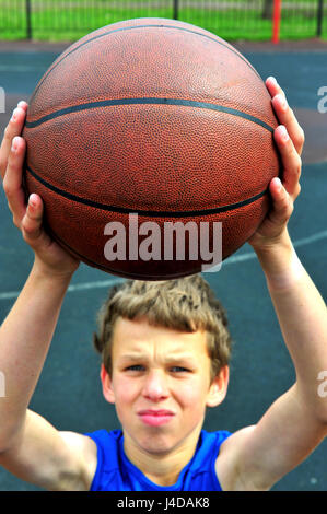 Jungen Basketball-Spieler, die Vorbereitung auf den Ball zu werfen Stockfoto