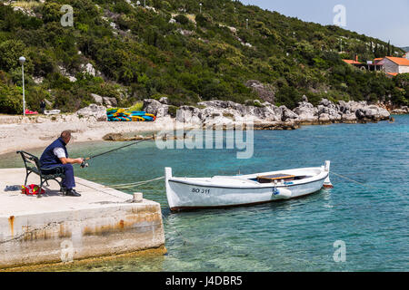 Ein Mann Fische vom Quai des Sudjuradj (eine der zwei wichtigsten Siedlungen auf der Insel Sipan) in Kroatien. Stockfoto