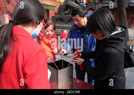 Gläubige halten Räucherstäbchen beten Yonghegong Lama Tempel in Peking, China, 25. Februar 2016. Stockfoto