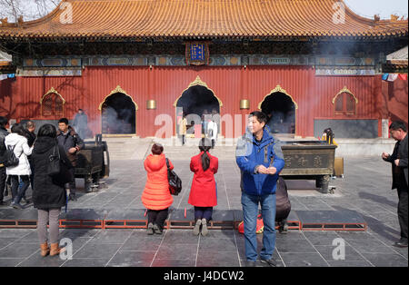 Gläubige halten Räucherstäbchen beten Yonghegong Lama Tempel in Peking, China, 25. Februar 2016. Stockfoto