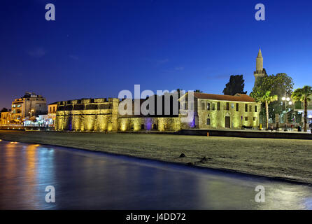 Nachtansicht des Schlosses Larnaca, Larnaca, Zypern. Im Hintergrund sehen Sie das Minarett der Kebir - Büyük ("große") Moschee. Stockfoto