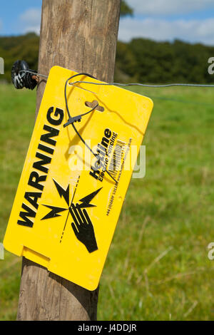 Warnschild, um Fußgänger vor elektrifizierten Zaun / elektrischen Zäunen zu warnen, um weidende Tiere vor dem Wandern zu verhindern und Feld / Felder / Ackerland vor Fußgängern & Eindringlingen zu schützen. VEREINIGTES KÖNIGREICH Stockfoto