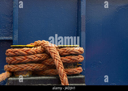 Die Rolle von orange Seil auf dunkle blaue Farbe Hintergrund Stockfoto