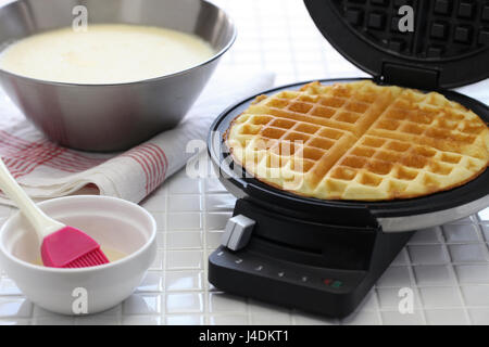 hausgemachte Waffeln vorbereiten von Waffle Maker Maschine. Stockfoto