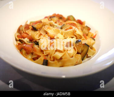 Leckere Pasta Spaghetti mit Gemüse und Käse in einem weißen Teller Stockfoto